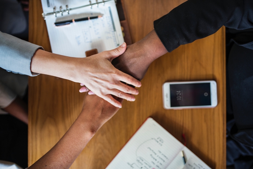 Three people putting hands together