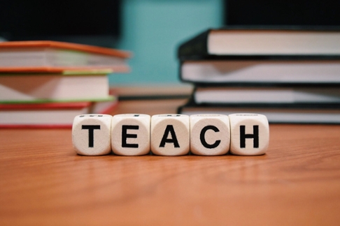 Scrabble tiles that spell teach