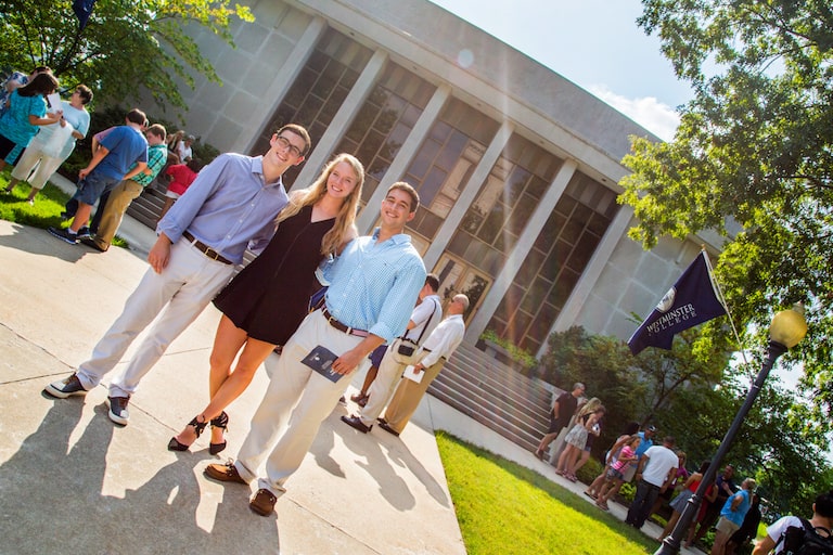 three students in front of campus building