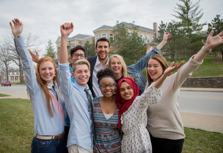 group of students with arms raised